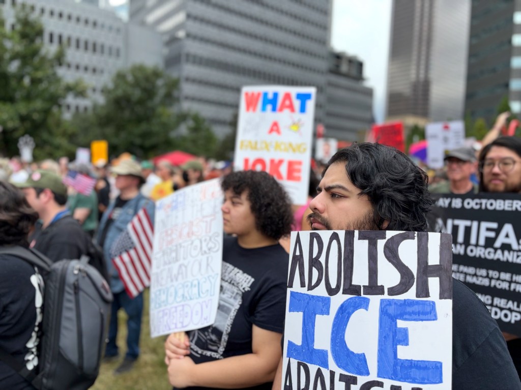 Man with sign calling to abolish ICE at Dallas No Kings protest.